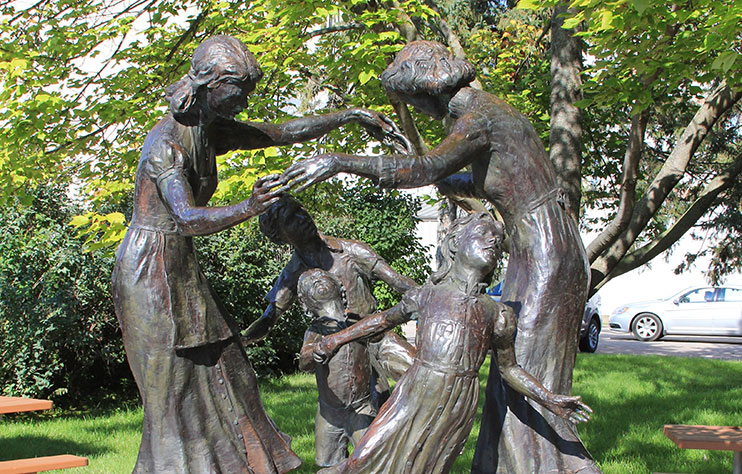 Statue titled "The Mothers" where two mothers play with their children.