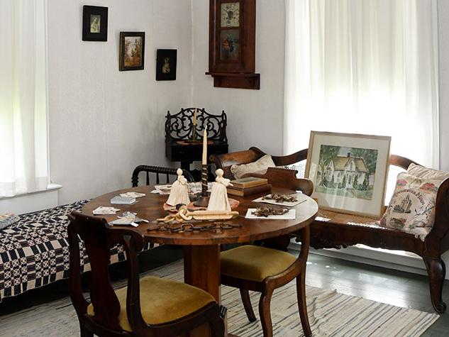 Interior of W. W. Mayo House showing a table set with dolls.